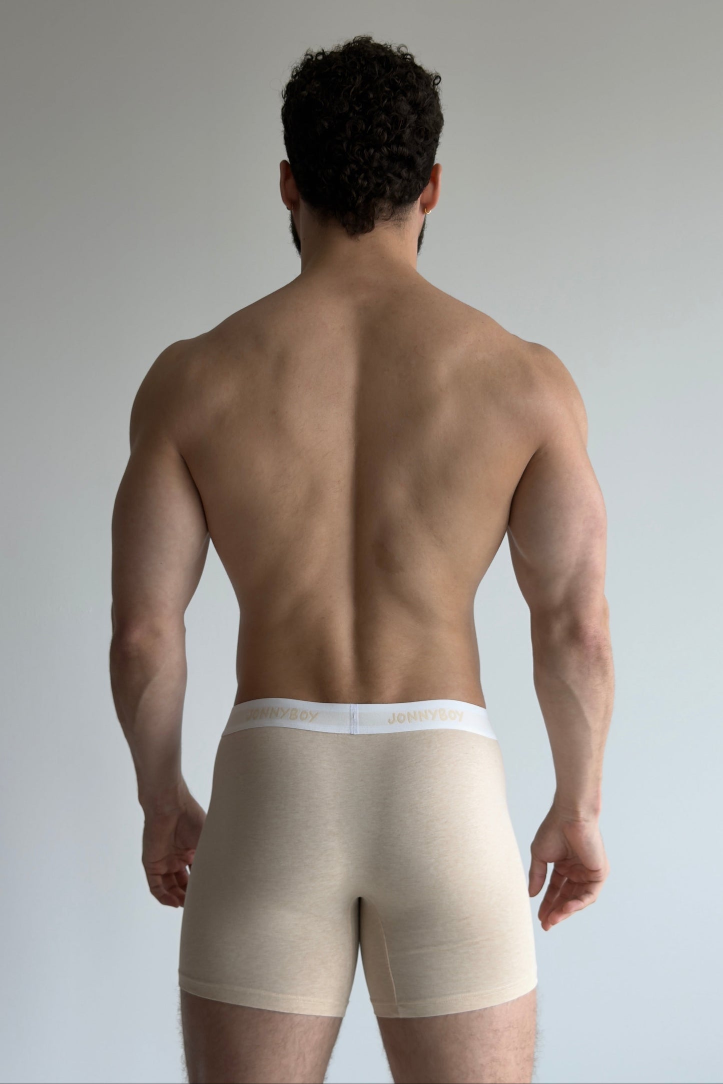 Man wearing beige compression garment on a plain background