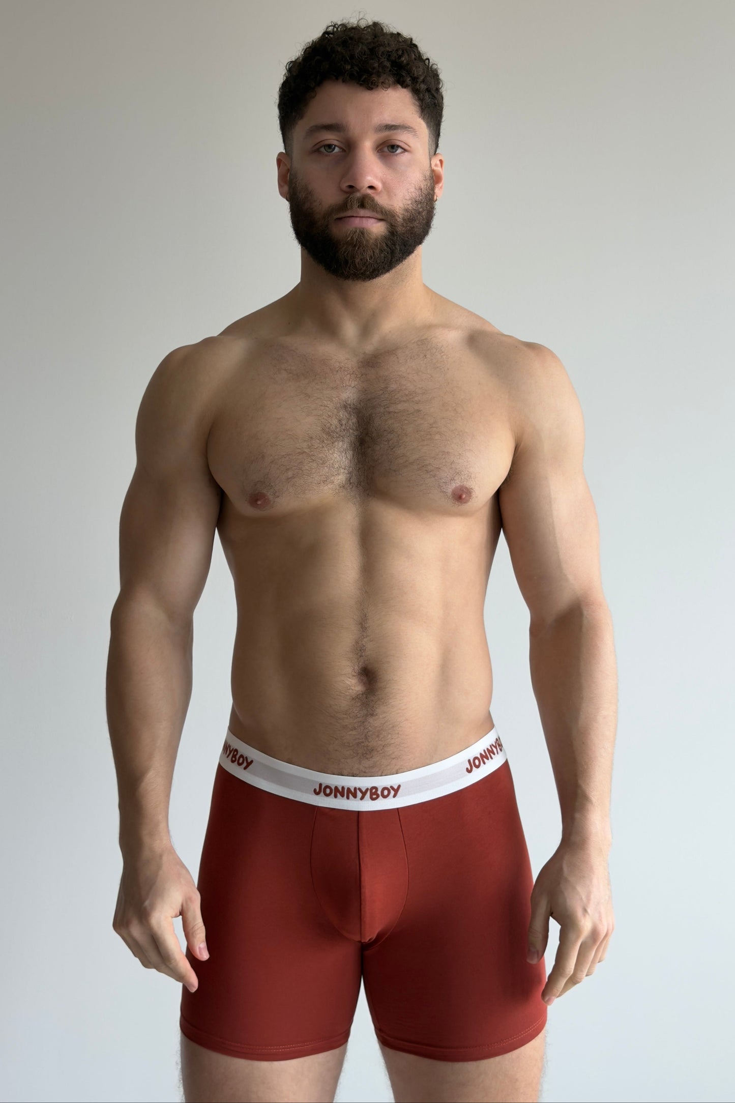 Man wearing red underwear with 'JOHNNYBOY' brand logo on a plain background